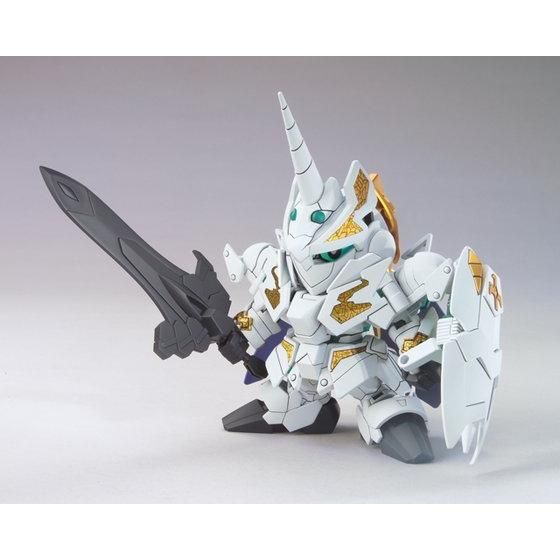 Model kit of a robot with white, gold, and black design on a gray background
