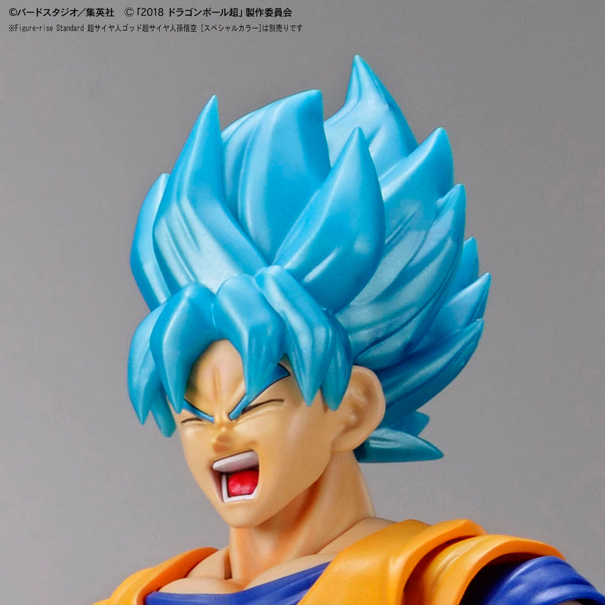 Figure with blue hair and orange outfit on a gray background