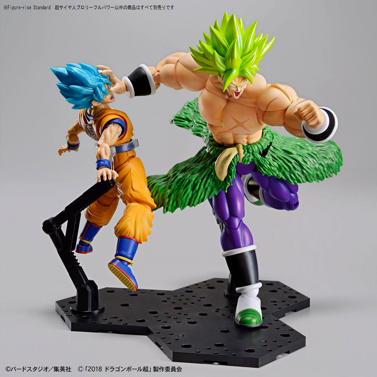 Two action figures on a gray background, one with blue hair and orange outfit, the other with green hair and purple outfit.