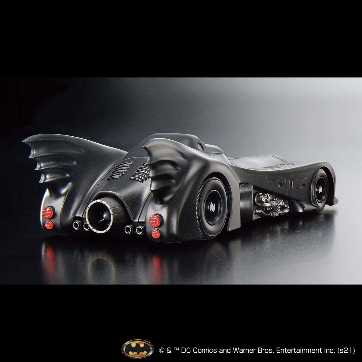 Batmobile model on a reflective surface with a dark background