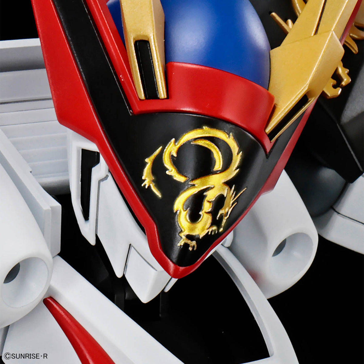 Close-up of a robot helmet with red, blue, and gold colors and a dragon emblem.