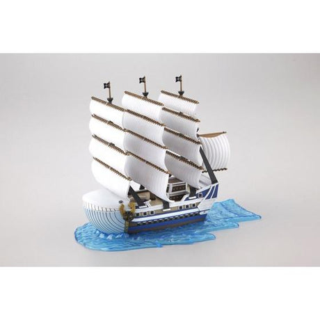 Model ship with white sails on a gray background
