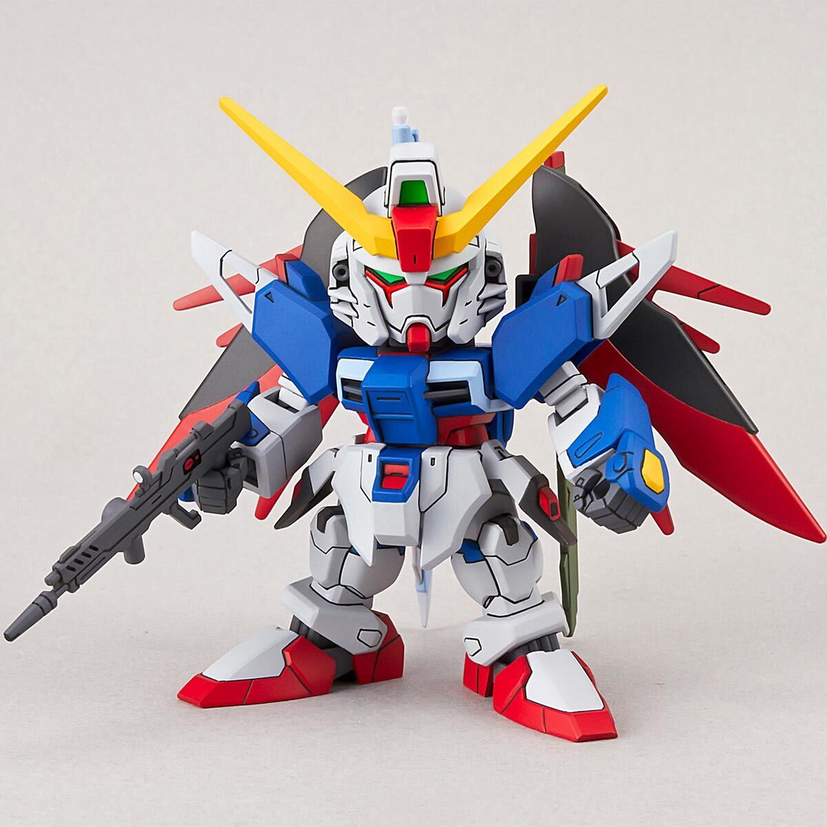 Colorful robot toy with red, blue, and yellow accents on a light gray background