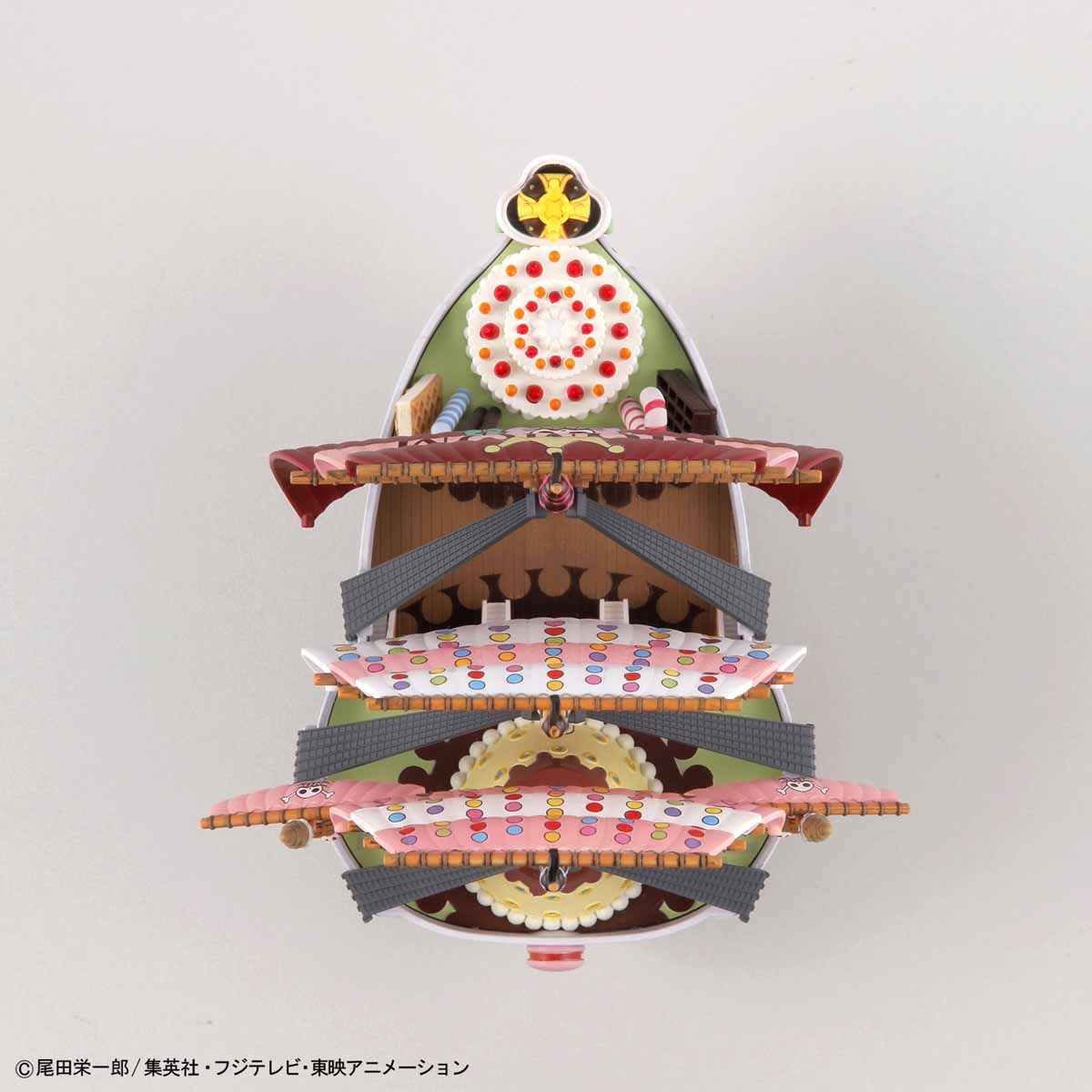 Three-tiered decorative stand with colorful design on a white background