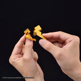 Two hands holding small golden plastic dice against a solid black background. A copyright watermark for Studio Dice/Shueisha TV Tokyo MX Kanjiama is visible in the bottom-left corner.