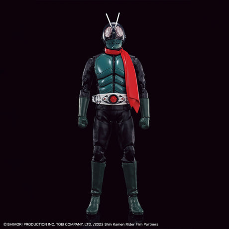 A full-body collectible figure of a Kamen Rider character in a dark green and black suit with a bright red scarf, standing against a solid black background. The figure has a silver chest plate with a red emblem, a silver belt, and antenna on the helmet.