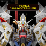 Front-facing close-up of a Gundam-style mecha figure with large white and gray armor, gold accents, red details, and blue lower section against a black background. Japanese promotional text appears across the top, and Sunrise branding is visible in the corner.