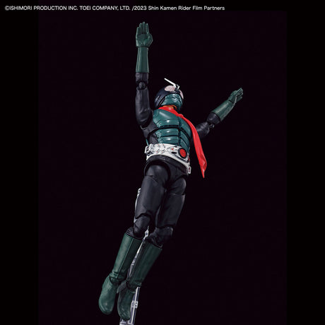 A collectible action figure of Kamen Rider in a dynamic jumping pose against a solid black background. The figure features a dark green and black bodysuit with a bright red cape and silver belt details.