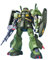 A green mobile robot action figure or model kit shown standing on a plain white background, holding a gray rifle and large dark shields, with small red, yellow, and blue accents.