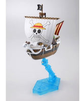 A miniature model of the One Piece Jolly Roger ship from the anime franchise, featuring a white sail with the iconic skull and crossbones wearing a straw hat, mounted on a translucent blue wave-like stand.