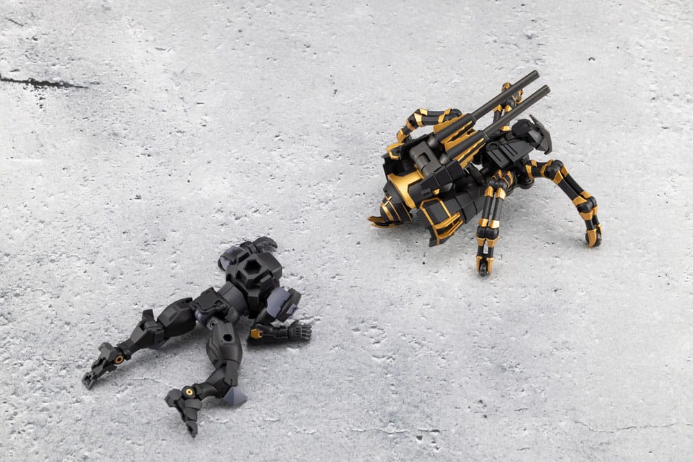Two toy robots, one black and one black with gold accents, on a gray concrete surface.