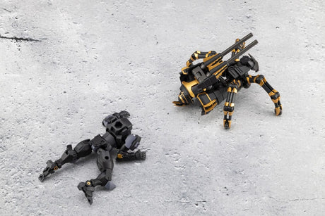 Two toy robots, one black and one black with gold accents, on a gray concrete surface.