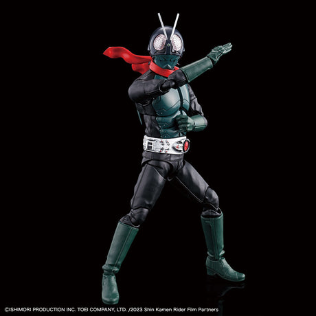 Shin Kamen Rider action figure posed in a dynamic fighting stance against a solid black background. The figure features a black and dark green bodysuit, a silver helmet with two antennae, a bright red cape, and a silver belt with a red Geki-Geki token.